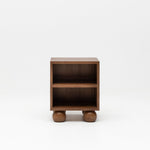 Wooden walnut bedside table with ball feet for nursery.