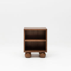 Wooden walnut bedside table with ball feet for nursery.