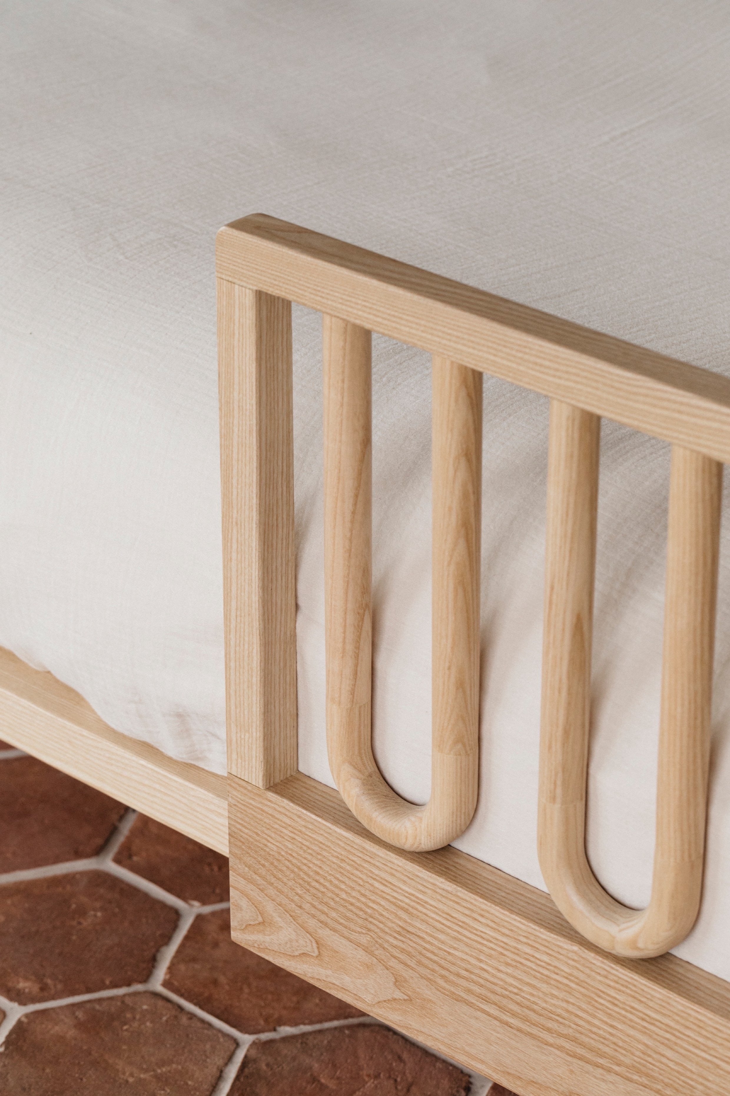Closeup of Arche Ashwood Toddler Bed Side Rail on a single children's bed with a white duvet