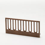 The Arche Walnut Toddler Bed Side Rail isolated on a white background to show natural wood grain and arched frame