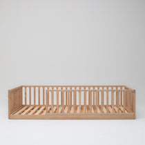 Solid Ashwood children's floor bed showing natural timber frame on white background