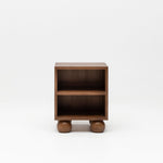 Wooden walnut bedside table with ball feet for nursery.