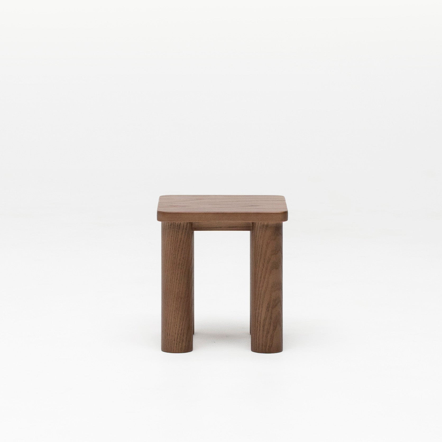 Walnut timber kid's stool with a square top and solid wood legs on a white background