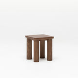 Side view of the Hennie Kids Stool Walnut showing curved top, natural grain and solid rounded legs