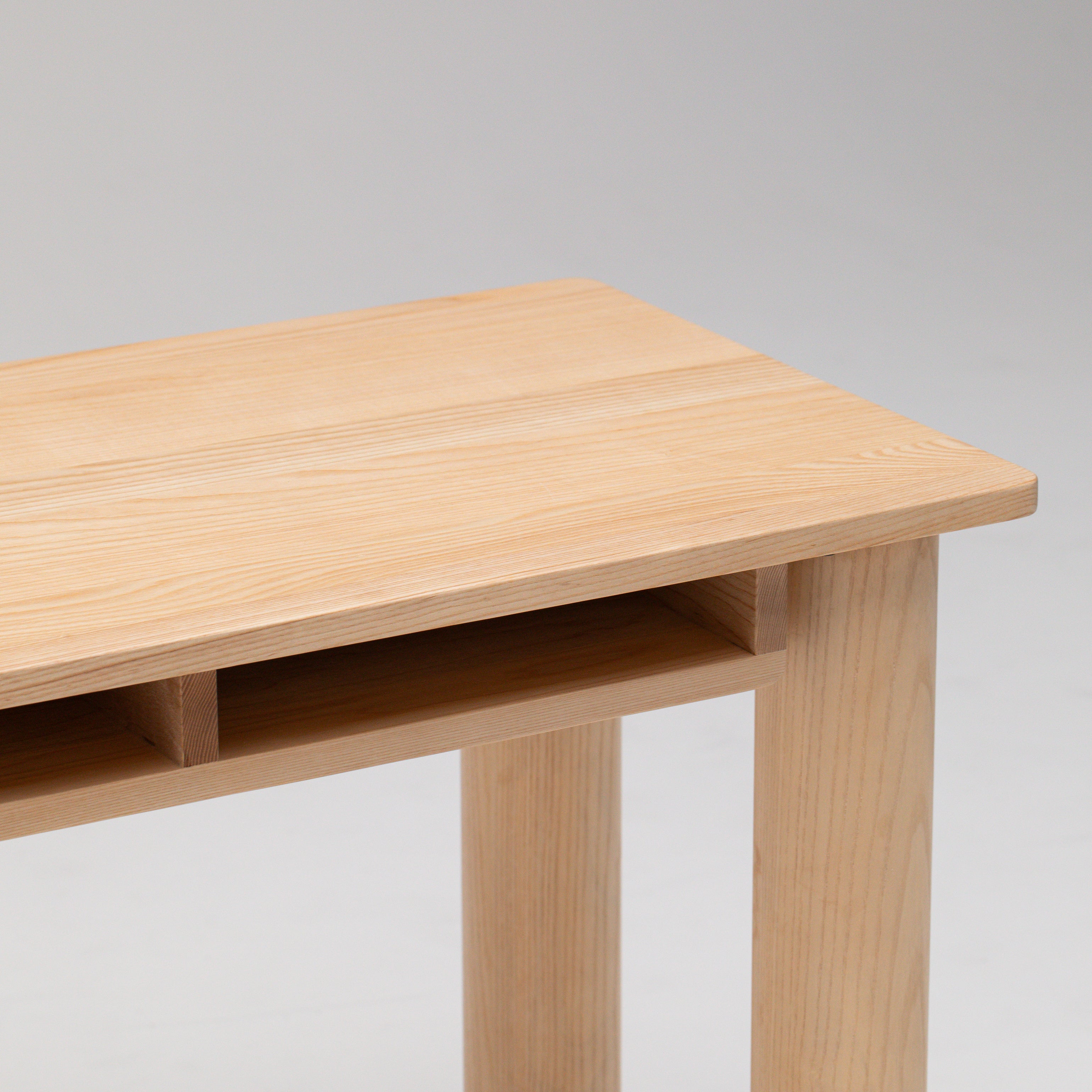 Top view of Hennie Kids Desk Ashwood showing desk table top rounded corner, natural wood grain and spaces for paper and homework 