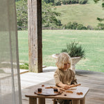 Young boy playing with wooden toys at the Hennie playtime table and stool set