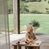 Young boy playing with wooden toys at the Hennie playtime table and stool set