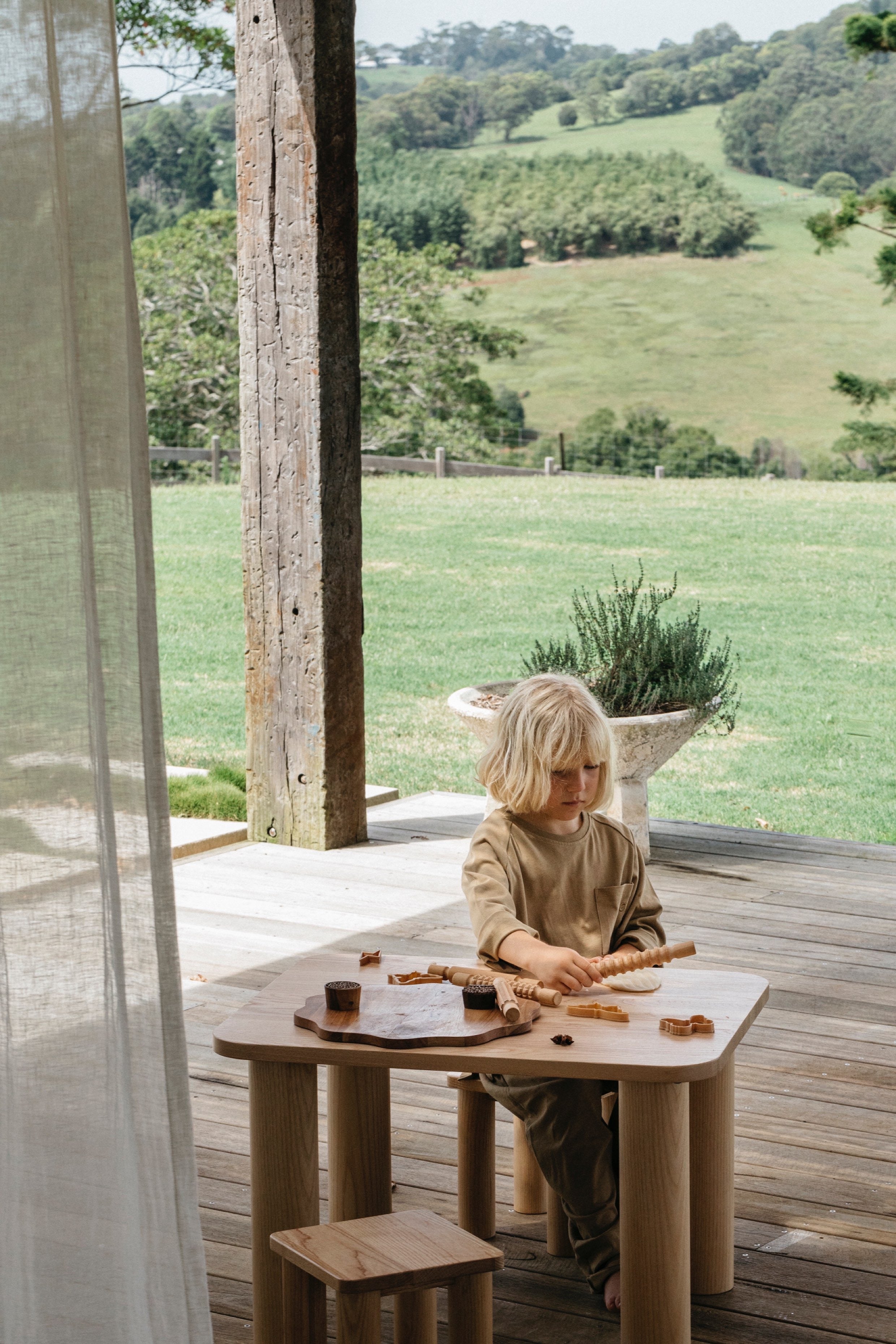 Young boy playing with wooden toys at the Hennie playtime table and stool set