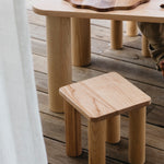 The Hennie Kids Stool Ashwood with the matching table outdoors on a balcony showing kids baking playtime toys