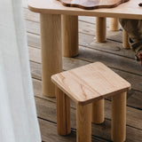 The Hennie Kids Stool Ashwood with the matching table outdoors on a balcony showing kids baking playtime toys