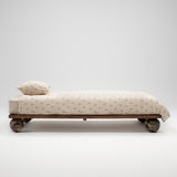 Daybed with wheels and a pillow on a white background