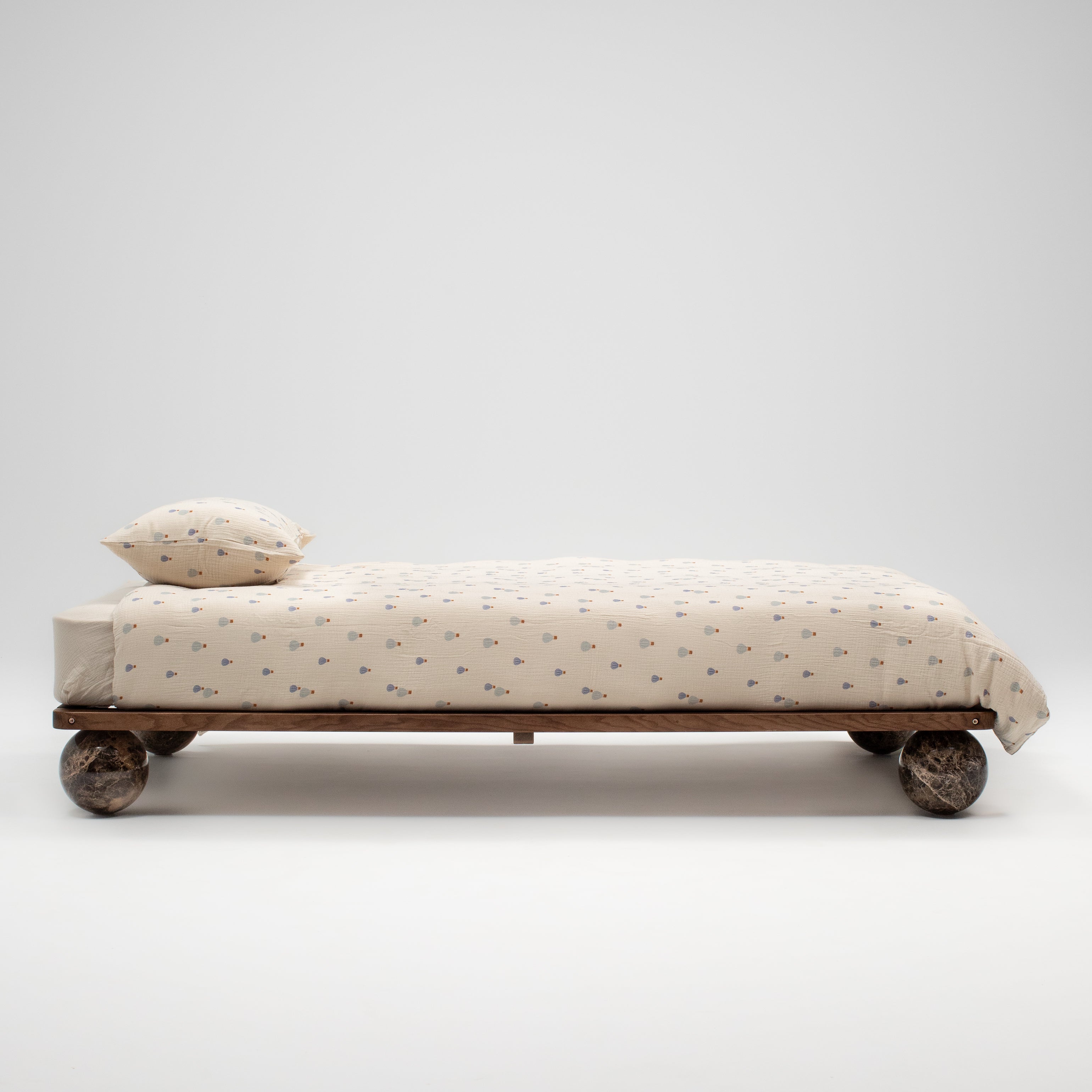 Daybed with wheels and a pillow on a white background