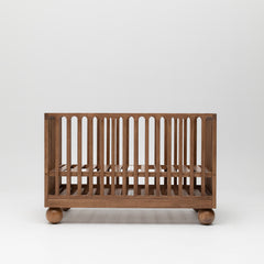 Zali Walnut Baby Cot featuring ball legs and adjustable base.