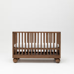 Solid wood walnut baby cot with mattress at highest height