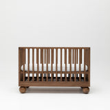 Solid wood walnut baby cot with mattress at highest height